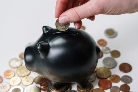 person holding black ceramic pig coin bank